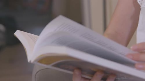 Close Up of Adult Reading Book Indoors