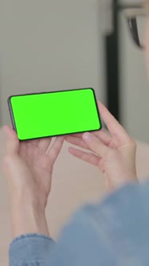 Rear View of Young Woman Holding Smartphone with Chroma Key, Vertical Video