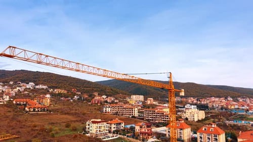 A large construction crane is set up in a mountainous region.