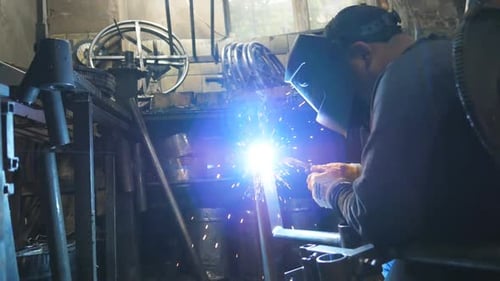 Metal Worker Welding in Industrial Setting