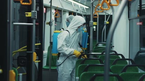 Workers in Hazmat Suits Disinfecting Bus Interior
