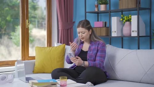 Woman Reacting to Phone with Sadness at Home