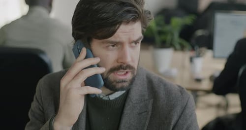 Young Adult Man Talking on Phone in Office