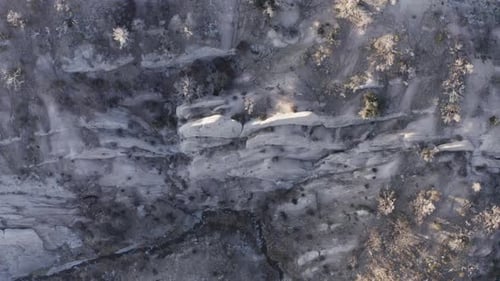 Top down view on a rocky and dry sand area on a sunny day with a small river