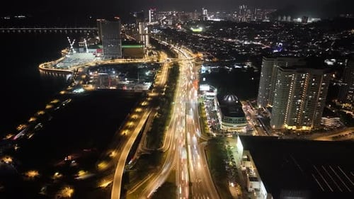 Drone aerial night highway with light trails over waterfront city