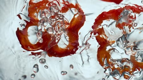 Red Bell Pepper Slices Falling Into Water