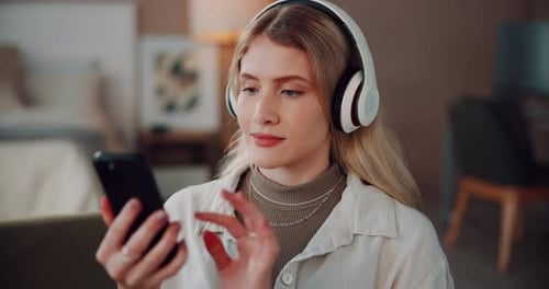 Young Woman Listening to Music on Phone Indoors