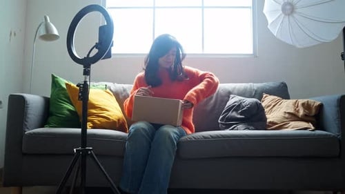Young Woman Unboxing a Package On Her Couch