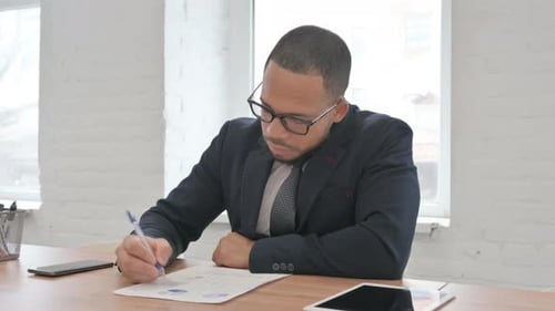 Mixed Race Businessman Working on Documents in Office
