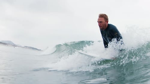 Surfer in wetsuit rides the wave on the south of Brazil