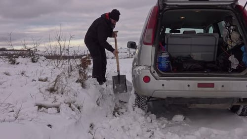Man Shoveling Snow in Rural Winter Landscape