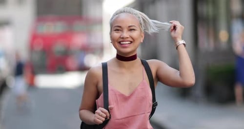 Smiling Woman with Blonde Hair Walking on City Street