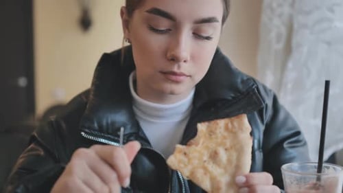 A Young Schoolgirl Eats at a Coffee Shop in the Fall