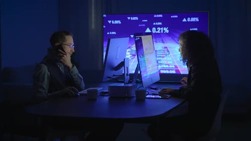 The Team is Deeply Engaged in Analyzing Complex Data Using Hightech Monitors in a Dark Room