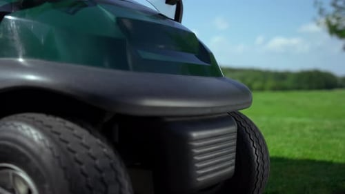 Empty Car Golf Course Outside. Golfing Buggy Tires Wheels Stand On Grass Close Up. No People In E...