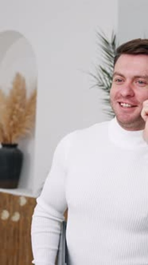 Man Talking on Phone Indoors with Laptop