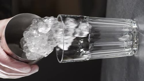Bartender Adds Ice Cubes Into Glass Slow Motion Making Cocktail at Bar Counter Vertical Footage