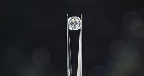 Sparkling Diamond Held by Metal Tweezers