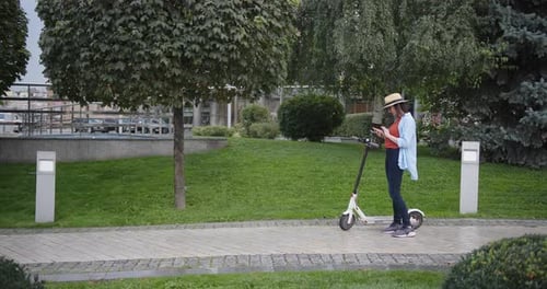 Woman with Phone Activates Electric Scooter with Qr Code in Green Park