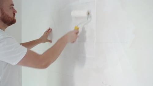 Painter Man Painting a Wall with a Roller