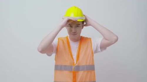 Portrait of male engineer wearing a protective helmet over white background studio.