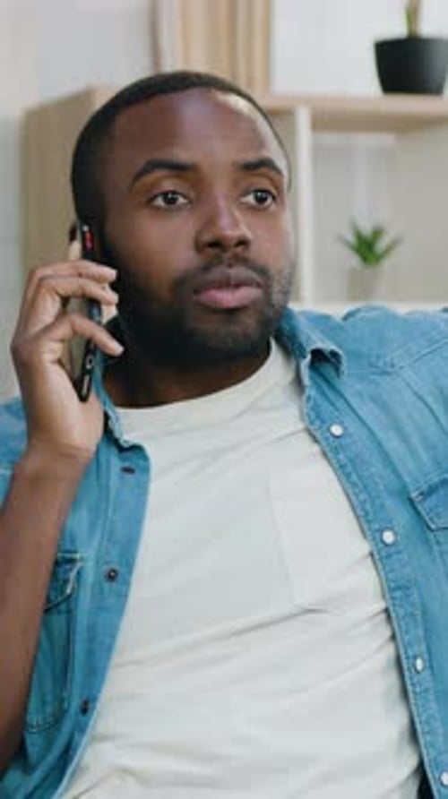 Young Man Chatting on Mobile Phone Indoors