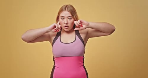Blonde Woman Covers Ears in Studio