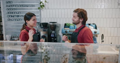 Young Cheerful Couple of Caucasian Cafe Workers Dance Near Bar Counter Celebrating Holiday Together