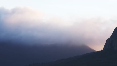 Time Lapse of Fog Moving Across a Mountain Range at Sunset in the Last Rays of the Sun Under a Clear