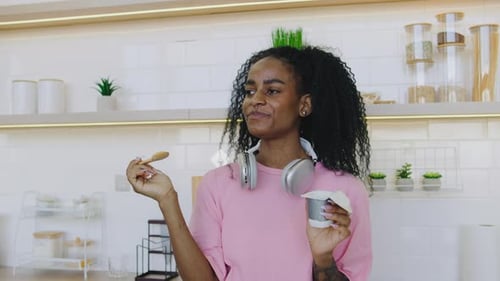 Young Woman Enjoys a Tasty Snack in Kitchen