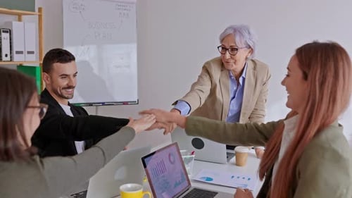 Diverse Group of Business People Stacking Hands Celebrating Success at Office