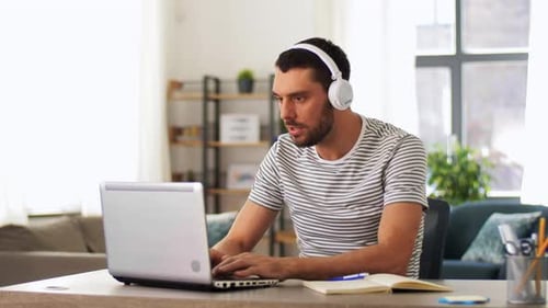 Man working on laptop at desk in home