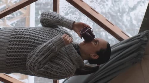 Mujer bebe té caliente en Dome Camping