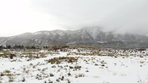 Winterscape Snow Covered Field And Rocky Mountains Range Near Estes Park, Colorado USA. 4K Drone. Ca