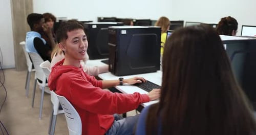 Gemischtrassige Studenten sprechen im Computerunterricht der Universität Academic zusammen