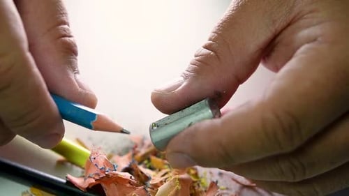 Footage of hands slowly sharpening a pencil and some coloured pencils with a Wedge Pencil Sharpener.