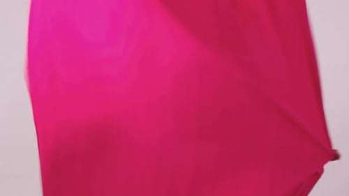 Young Slim Woman Dancing with Pink Cloth in the White Studio Looking in the Camera