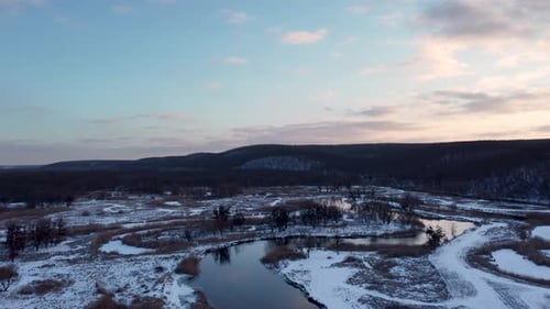 Flusskurve mit malerischen Sonnenuntergangswolken im Winter