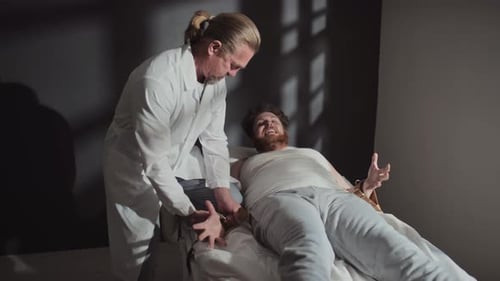 Doctor Examining Bound Patient in Hospital Room