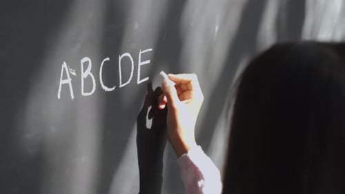 Grundschülerin, Schülerin, die Kreide auf Tafel schreibt. Kind Preteen