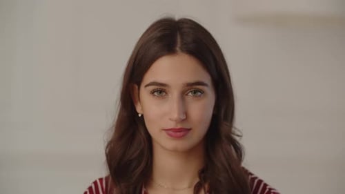 Portrait Shot of a Young Brunette Woman Smiling at the Camera Front View of Cheerful Girl on a White