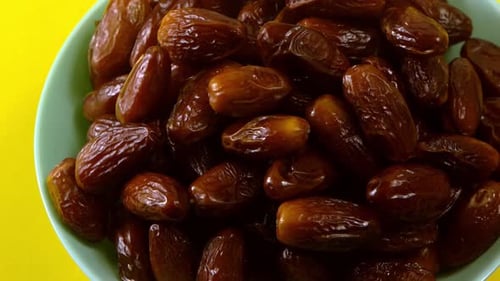 Dates in bowl against a yellow background