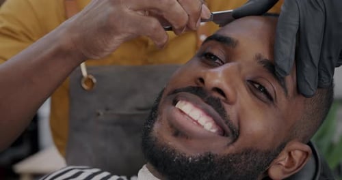 Barber Giving Man a Haircut with a Razor