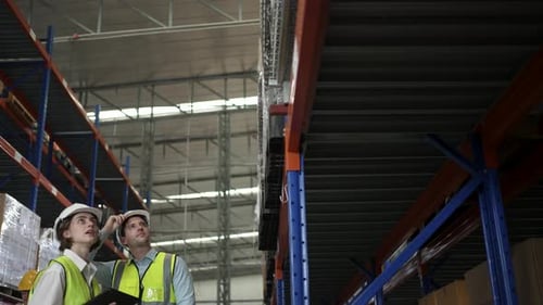 Blue collar workers are working and meeting at warehouse.