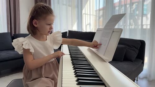 Young Child Playing Piano in Bright Home