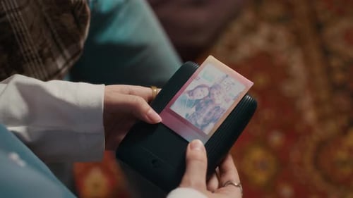 Dos amigas mirando una selfie impresa desde una impresora fotográfica instantánea