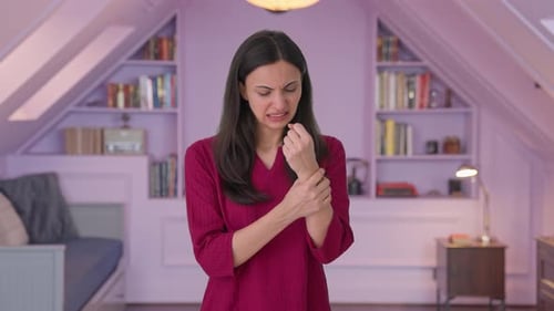 Woman Experiencing Wrist Pain in Cozy Room