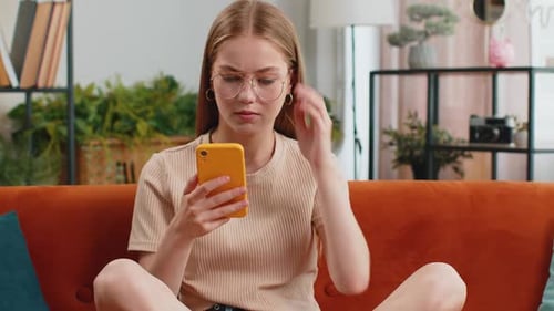 Woman Using Phone Lays Down on Couch