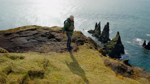 Man Looking At Rock Formations On The Sea