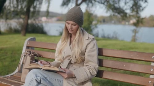 Young Woman Enjoys Quiet Reading Time in Nature By the Lake